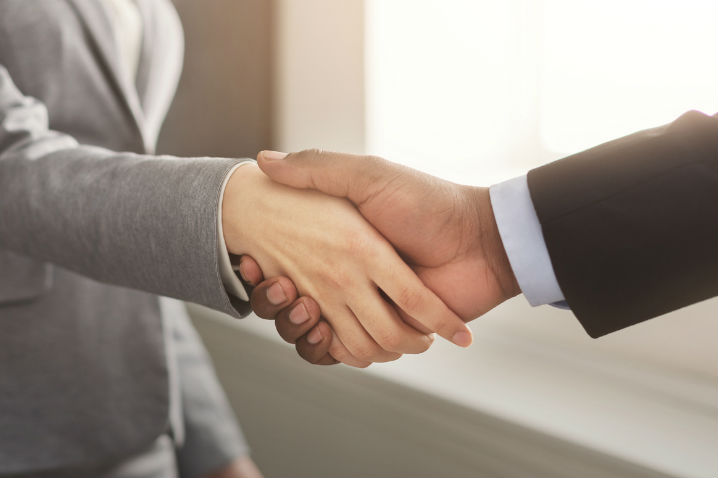 Businesswoman and businessman shaking hands