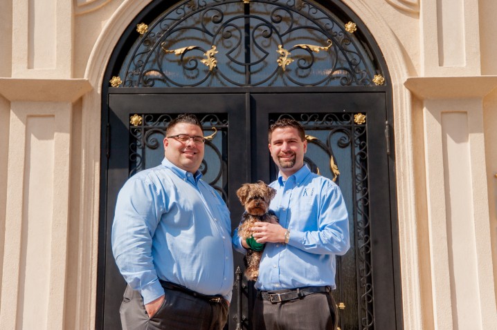 K9 Resorts owners holding dog in front of K9 Resorts building